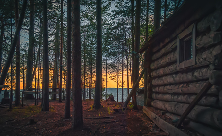 Old fishing hut in the woods on the shore of Lake Onega at sunset.の写真素材
