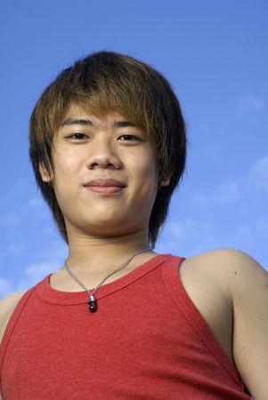 Smiling asian man with blue skyの写真素材