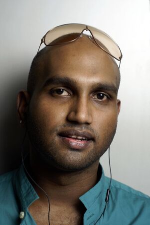 Indian man wearing earphones portraitの写真素材