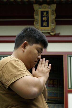 Asian man praying in templeの写真素材