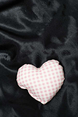 Love shaped cushion on black stainの写真素材