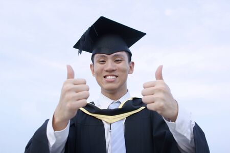 Happy asian graduate thumbs upの写真素材