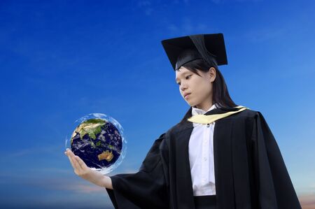 Asian graduate lady holding earth globe with skyの写真素材