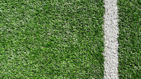 Photo of a green synthetic grass sports field with white line shot from above.の写真素材