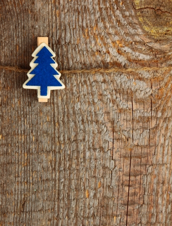 Clothes-peg in shape of Christmas tree on old wooden backgroundの写真素材