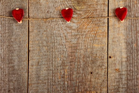 Clothes-peg in shape of heart on old wooden backgroundの写真素材