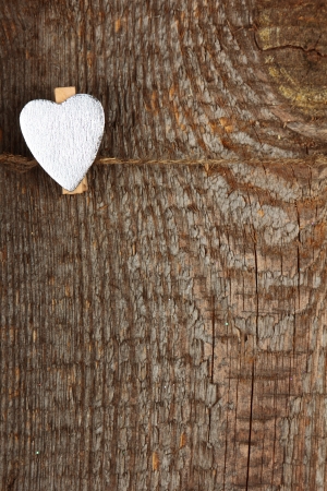 Clothes-peg in shape of heart on old wooden backgroundの写真素材