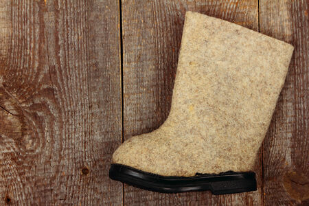 Russian traditional winter felt boot valenki on wooden background