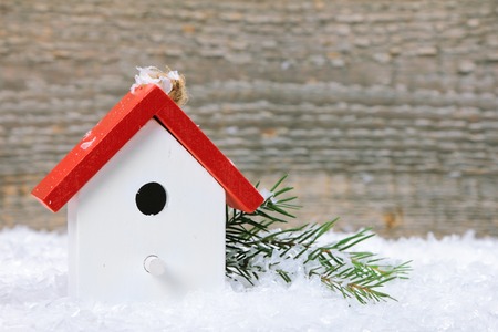 One birdhouse on snow with wooden backgroundの写真素材