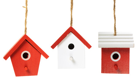 Three painted birdhouses hanging on white backgroundの写真素材