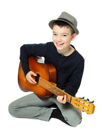 Portrait of eleven years old boy playing guitar on white backgroundの写真素材