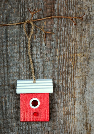 One birdhouse painted with red and white colors on old wooden backgroundの写真素材