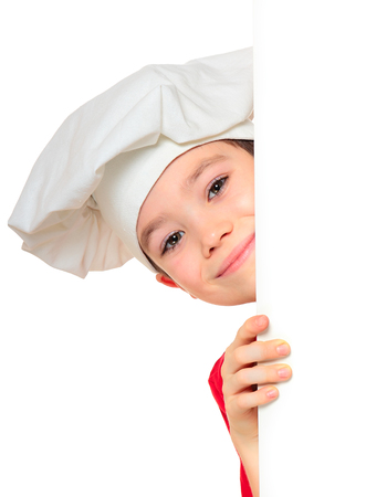 Chef boy looking from behind the wall isolated on white backgroundの写真素材