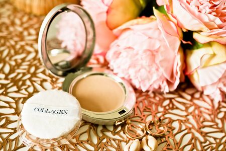 Cosmetic face powder, Compact powder with puff on golden pattern background with flowers.の写真素材