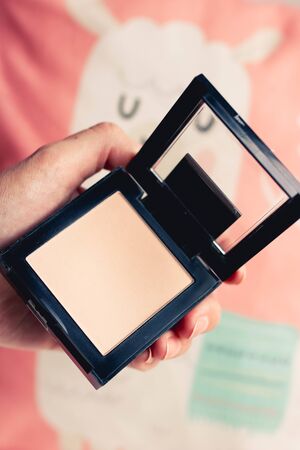 Make up powder in woman hands. Professional makeup products with cosmetic beauty products, foundation, face powder, eye shadows, eye lashes.の写真素材