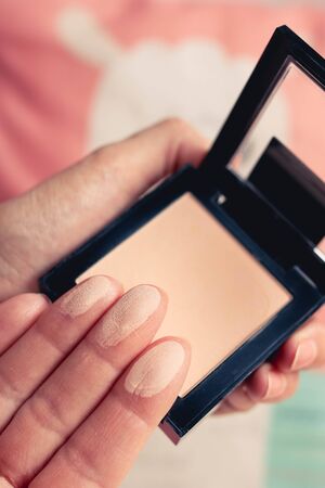 Swatches of face powder palette on a female fingers. Blurred background.の写真素材