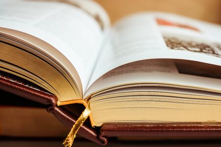 Close up of large book pages. Large open book on stack of books. Educational background.の写真素材