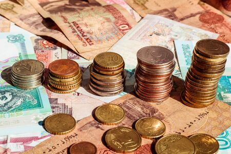 Stacks of coins forming income growth on banknote background.の写真素材