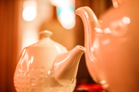 Two white ceramic teapots on a deep blurred background. Tea ceremony background.の写真素材