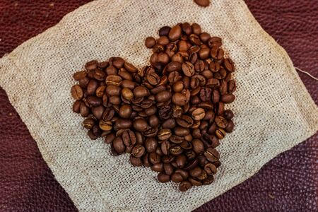 Coffee beans in shape of a heart, on old vintage wooden background. Close-up.の写真素材