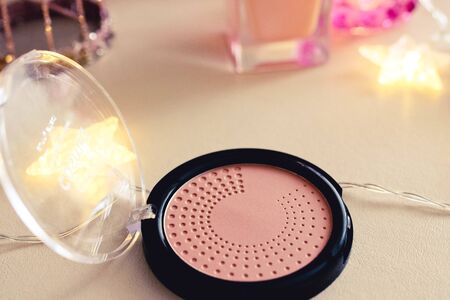 Close up view of woman hands holding broken make up powder in round shape container, red colored nailsの写真素材