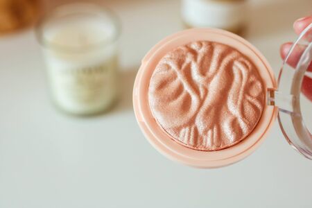 Decorative cosmetics, open compact powder case, beige textured bronzer. Professional make up box. Top view, blurred background.の写真素材