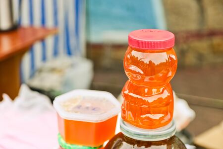 Honey in a glass jar on a blurred background. Homemade honeyon a craft market stall.の写真素材