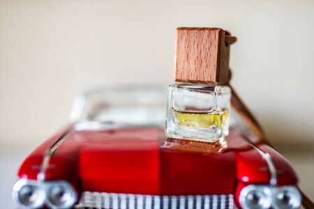 Car air perfume freshener bottle on the hood of a toy car. Aromatic liquid in the small bottle.の写真素材