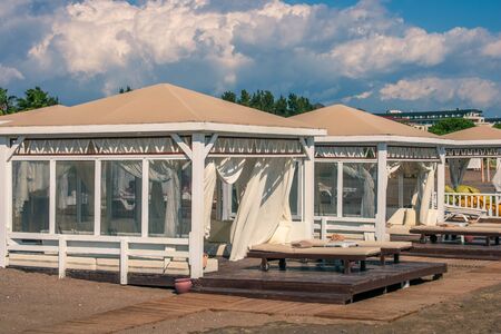 Beach tents. Beach front dual leather relax chairs near the beach tent facing the sea. Sunny day.の写真素材