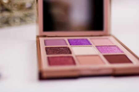 Nine colors eye shadow kit isolated on a white white cosmetic table.