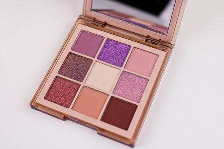 Nine colors eye shadow kit isolated on a white cosmetic table. Multicolored eyeshadow tints.の写真素材