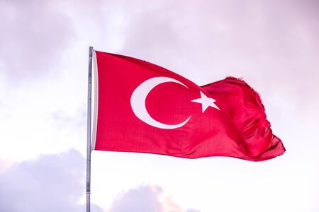 Turkish flag develops against the blue sky on a Sunny day.