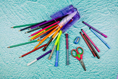 Multicolored paper pencils and markers in decorative glass scattered on the floor. Pencils for drawing. Paper art and craft. Minimal art concept. Creative flat lay.の写真素材