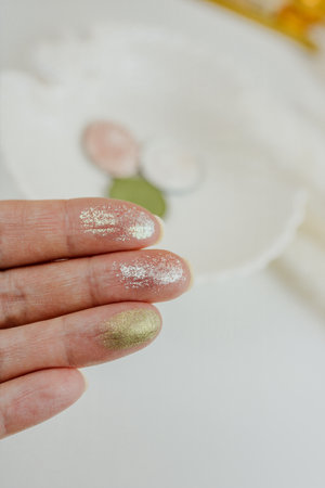 Swatches of colorful eye shadows on a woman's fingers. White background. High quality photoの写真素材