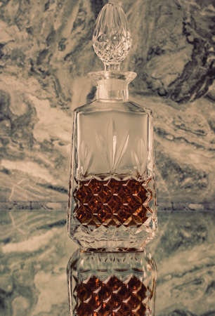 Crystal whiskey decanter on a glass table in bar. Vertical photo.の写真素材