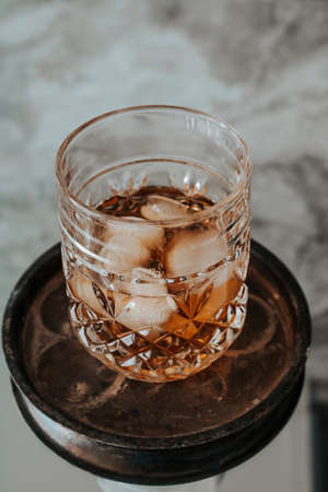 Glass of whiskey on an old iron standの写真素材