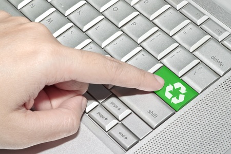 Hand pressing on green recycle sign keyboard button