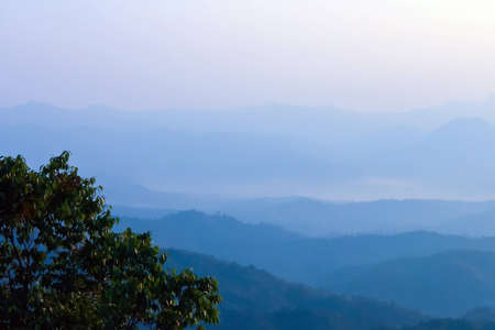 Morning mist and layers of tropical mountain at Huai Nam Dang National Park in Mae Hong Son, Thailand の写真素材