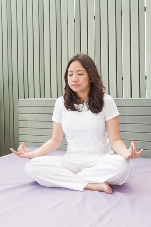 Attractive young asian woman practicing yoga meditation at sunriseの写真素材