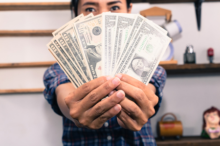 Happy  woman  with dollar bills showing thumb up.の写真素材