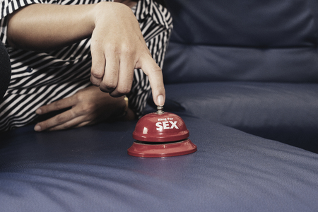 Woman's hand ring the bell for sex.の写真素材