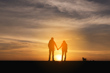 Silhouette of the Couple walking on the road near the sea. Family travel and healthy lifestyle concept.の写真素材