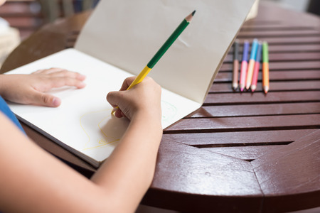 Little girl drawing with Crayon on the table.の写真素材