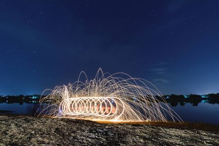 Wielding fire from burning steel wool.Steel wool spinning, fire shower concept abstract background.