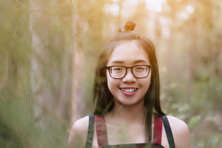 The girl smiled in a pine forest at  the summer season.Travel conceptの写真素材
