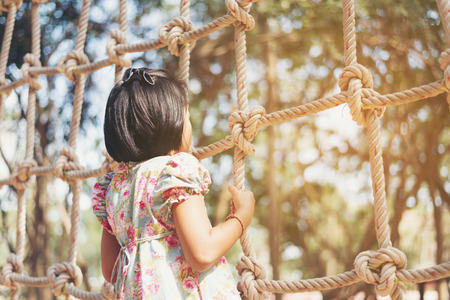 Child climbing in a rope playground structure at park  on a summer dayの写真素材