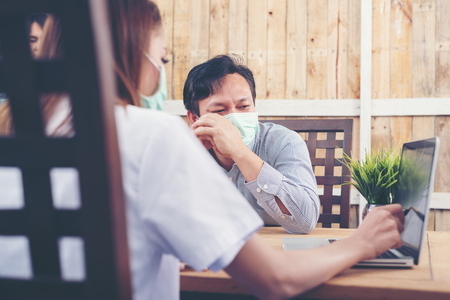 Worried patient  talking to doctor in medical officeの写真素材