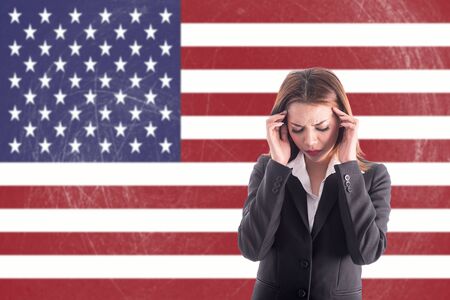 Asian girl with headache over USA flag background.Stressful girl with learning Englishの写真素材
