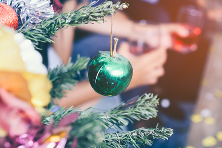 Christmas tree and Christmas decorations with hand holding the glass of red wine backgroundの写真素材