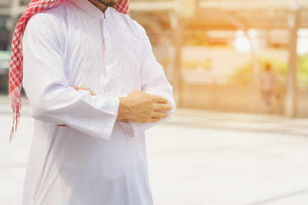 Muslim man wearing white traditional cloth praying and practicing the Islamic faith in the cityの写真素材